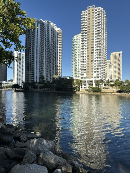 Biscayne Bay right near Brickell Key. Water reflects buildings with a brilliant blue sky. 